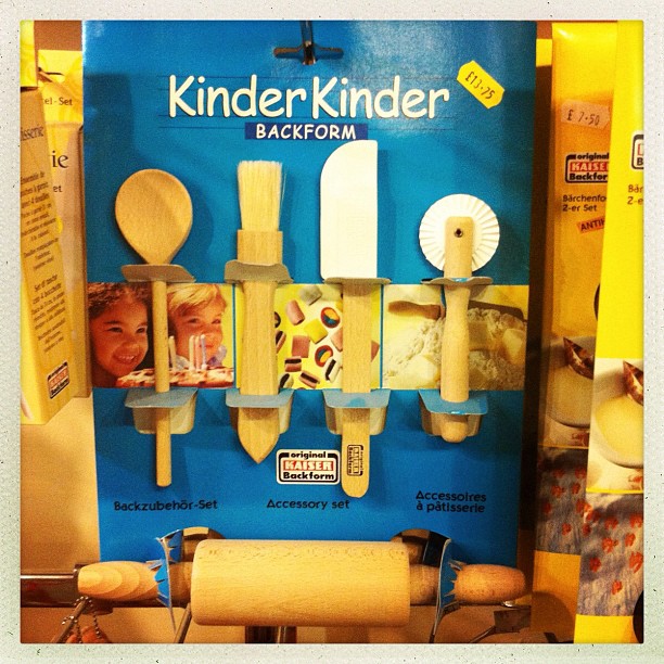 Kinder Backform baking tool set in packaging, showing wooden utensils and rolling pin displayed on blue cardboard backing.