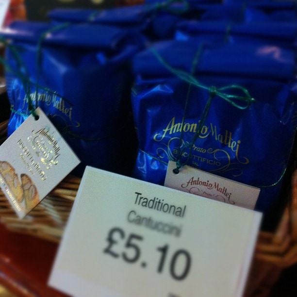Blue bottles of Antonio Mollor wine displayed with a price label showing Traditional Cantuso £5.10 on a wooden surface.