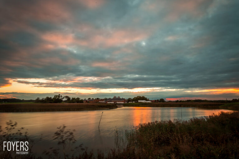 Dark clouds with an orange sunset glow over Snape Maltings, Suffolk