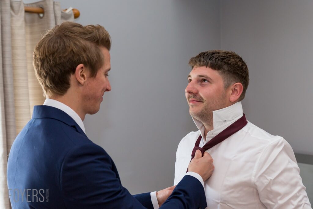 Alex getting his tie put on by best man MAtt
