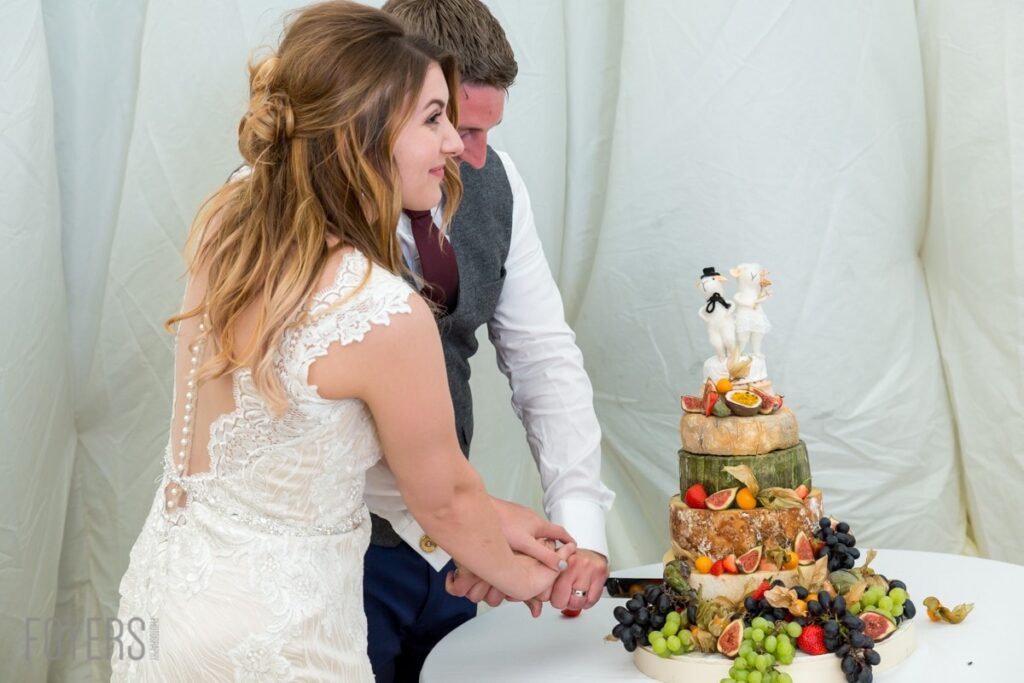 Ally and Alex cutting the cake made of cheese