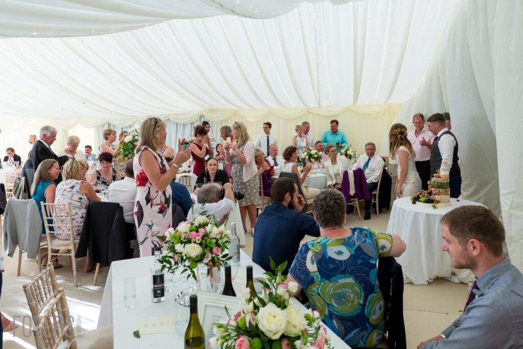 guest watching the wedding cake being cut