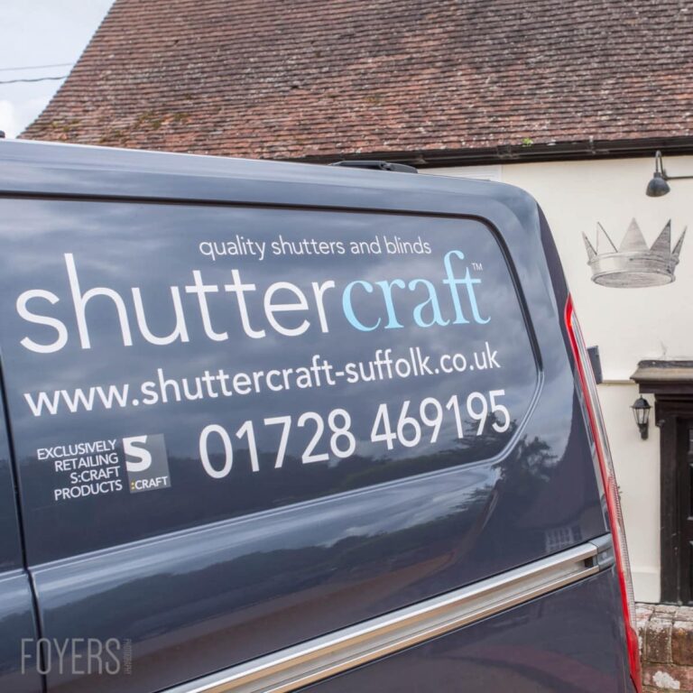 Shuttercraft van parked outside a cottage, displaying company branding and contact details on its rear window.