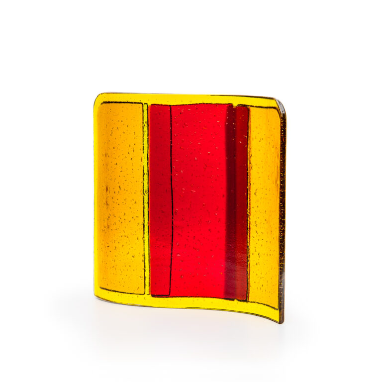 A glass block with yellow edges and a red centre, shown against a white background.
