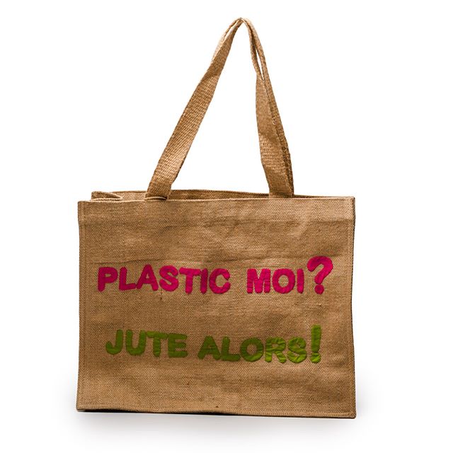 A jute tote bag with pink text reading PLASTIC MOI? and green text reading JUTE ALORS! against a white background.
