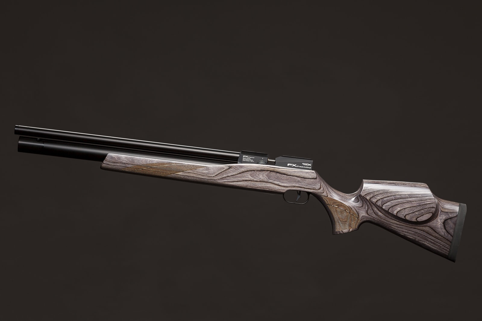 A side-view of a break-action air rifle with a laminated wood stock against a dark grey background.