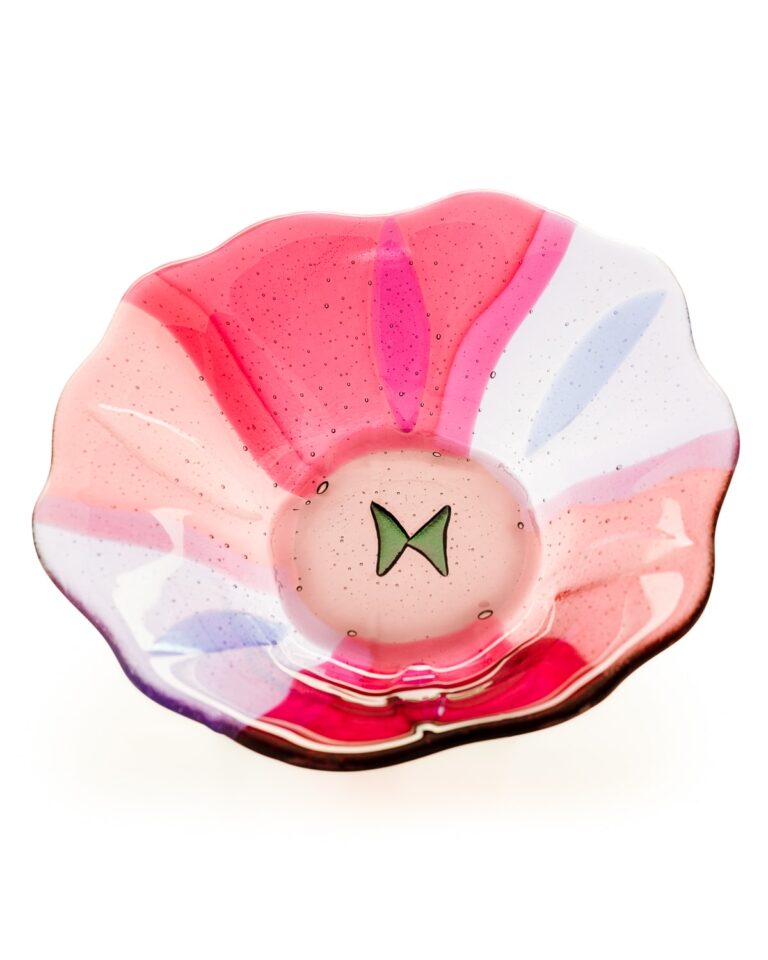A pink and white shell-shaped dish with glitter, featuring a green bow design in the centre, against a white background.