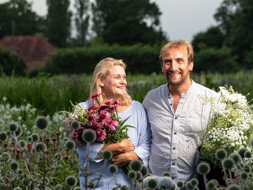 Personal branding photograph of a couple holding cut flowers in a flower field, for The Southwold Flower Company