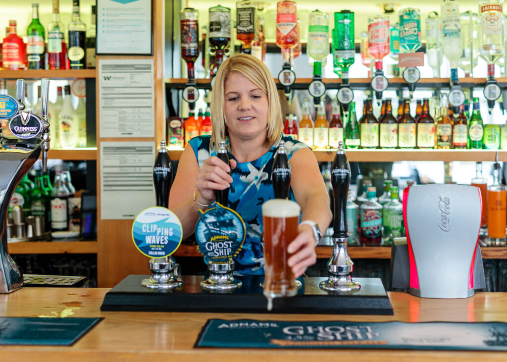 Personal branding photograph of a barmaid pulling a pint at The Randolph Hotel