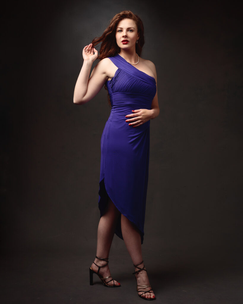 Full-length portrait of Isabelle in a purple one-shoulder dress with asymmetric hem, strappy heels