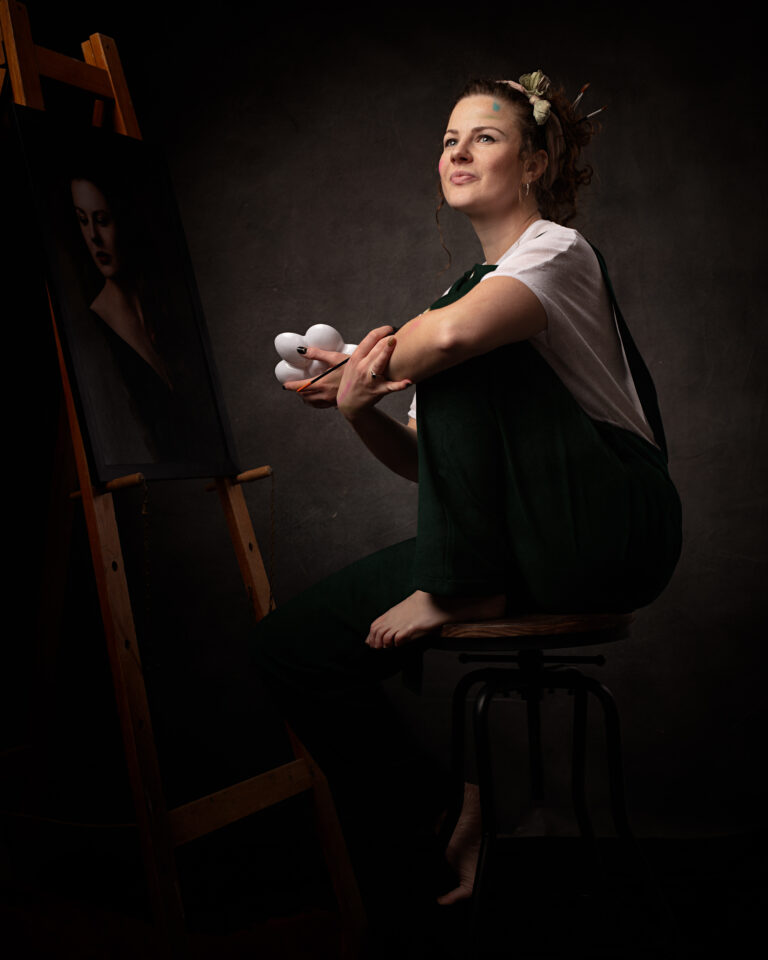 Isabelle exudes creativity and confidence as she models in her studio for a portrait photography session. As a painter, she knows the therapeutic benefits of artistic expression and uses it as a way to improve her mental health. The photograph captures the essence of her talent and unique spirit.