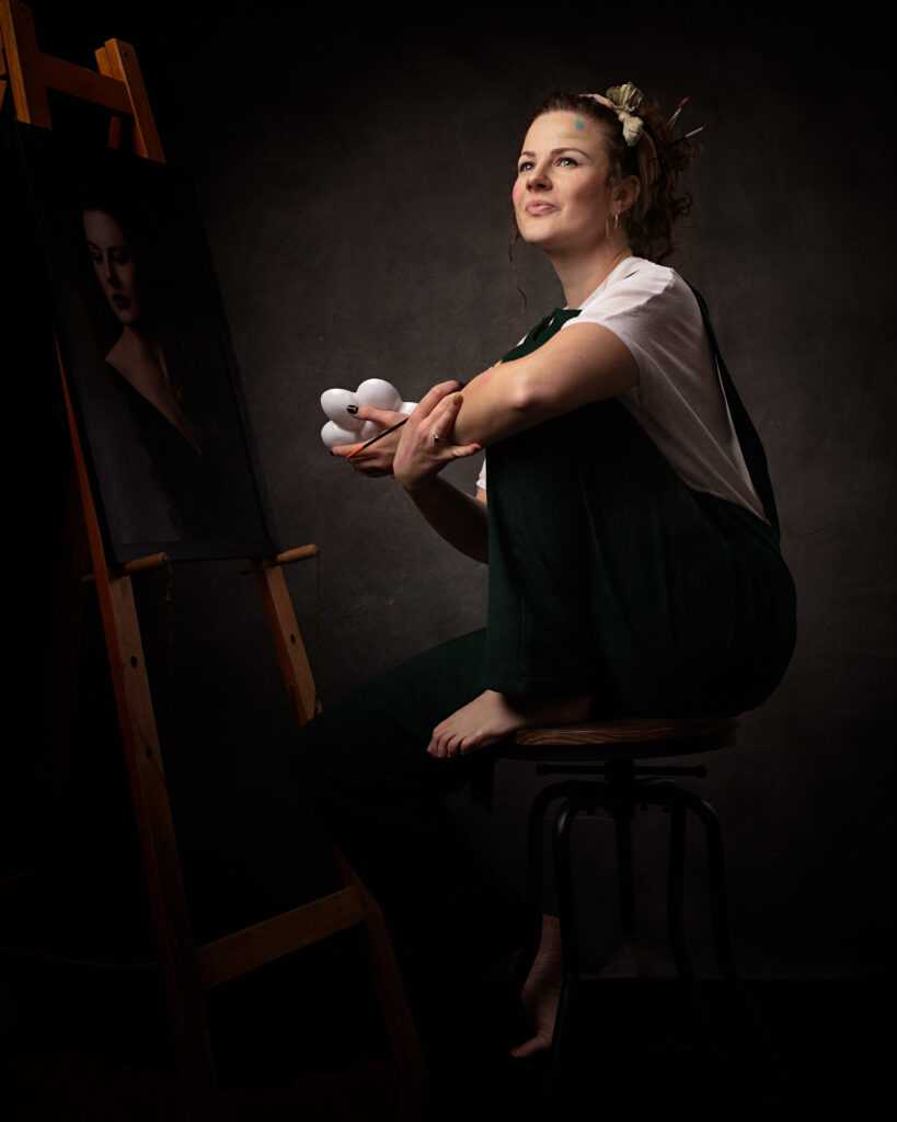 Isabelle exudes creativity and confidence as she models in her studio for a portrait photography session. As a painter, she knows the therapeutic benefits of artistic expression and uses it as a way to improve her mental health. The photograph captures the essence of her talent and unique spirit.
