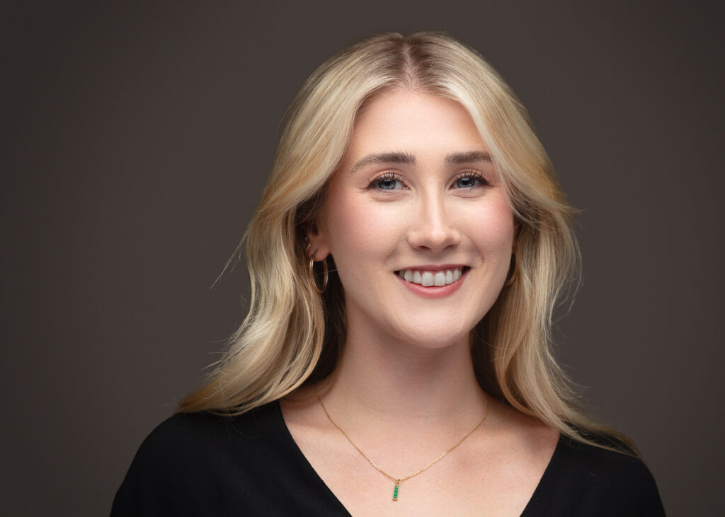 Smiling woman with blonde hair and black top.