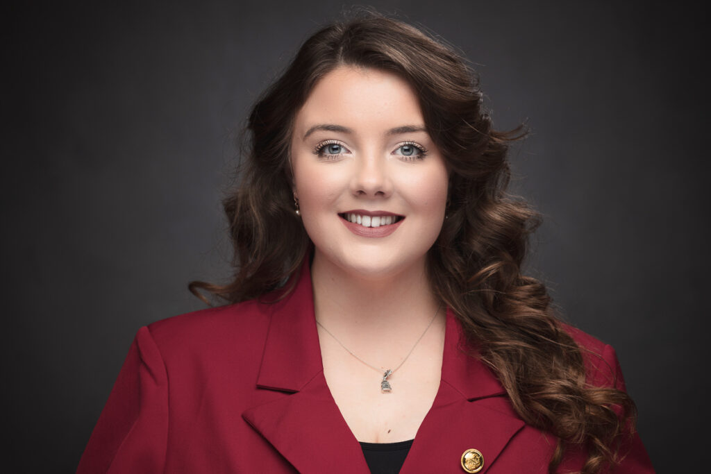 Woman in red blazer smiling for a headshot.