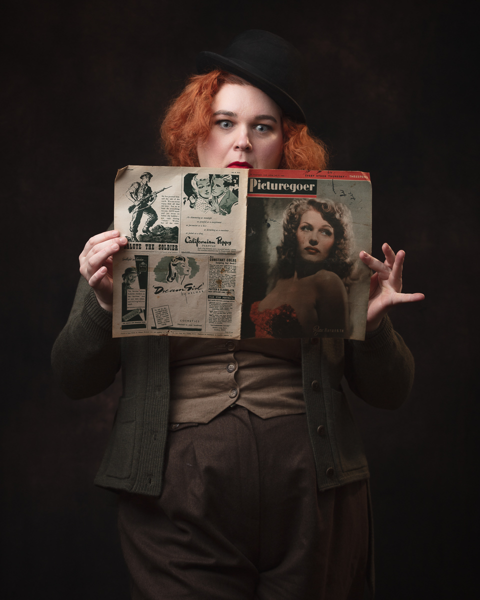 Person reading vintage Picturegoer magazine, surprised expression.