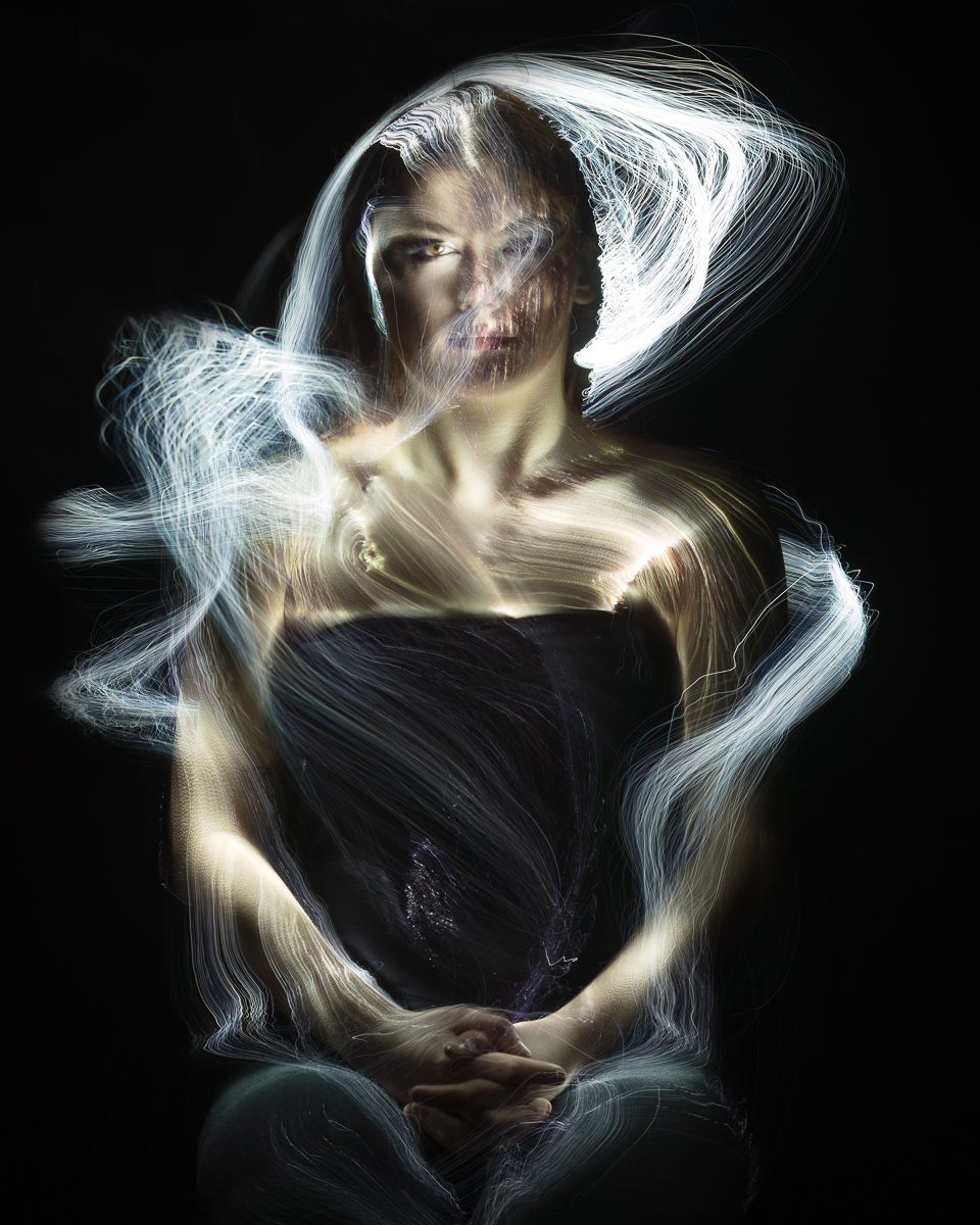 Artistic portrait with ethereal light trails.