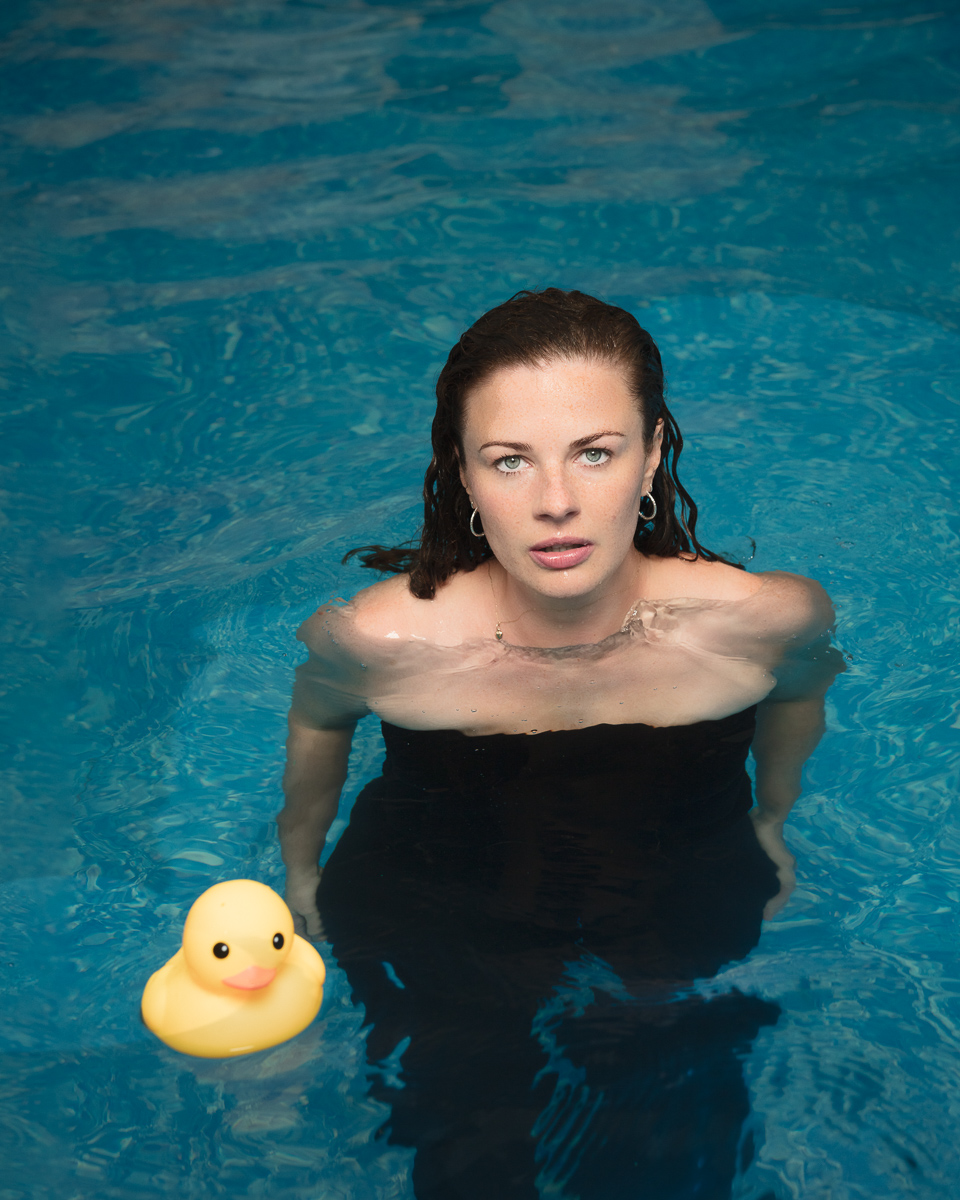 Woman in pool with yellow rubber duck.