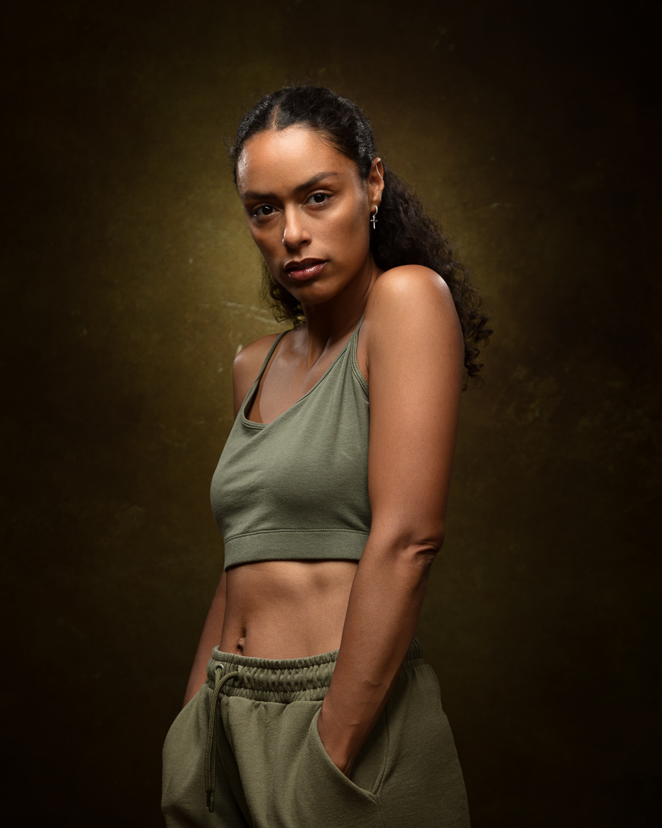 Woman in olive sports bra and shorts, studio portrait