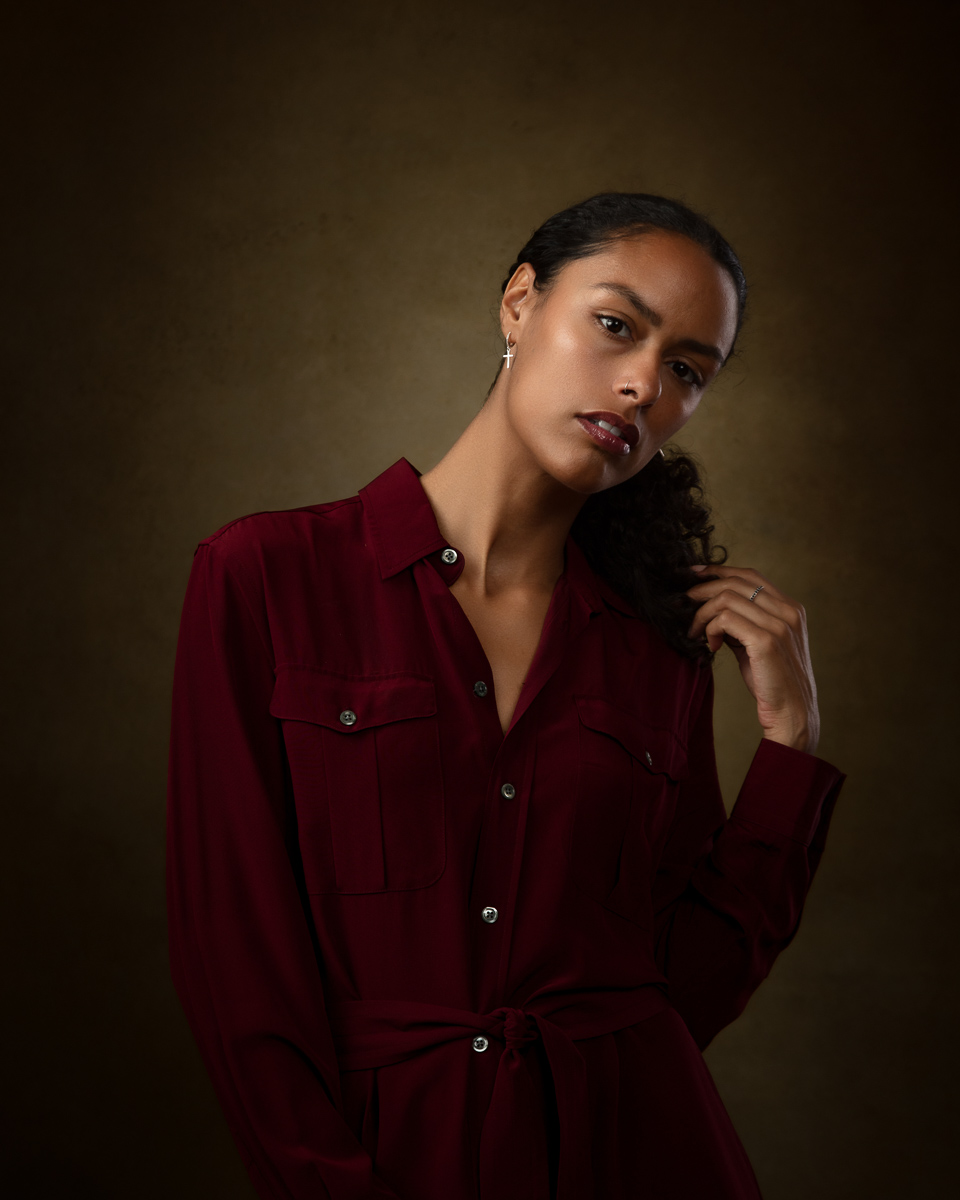 Woman in burgundy shirt against neutral background portrait