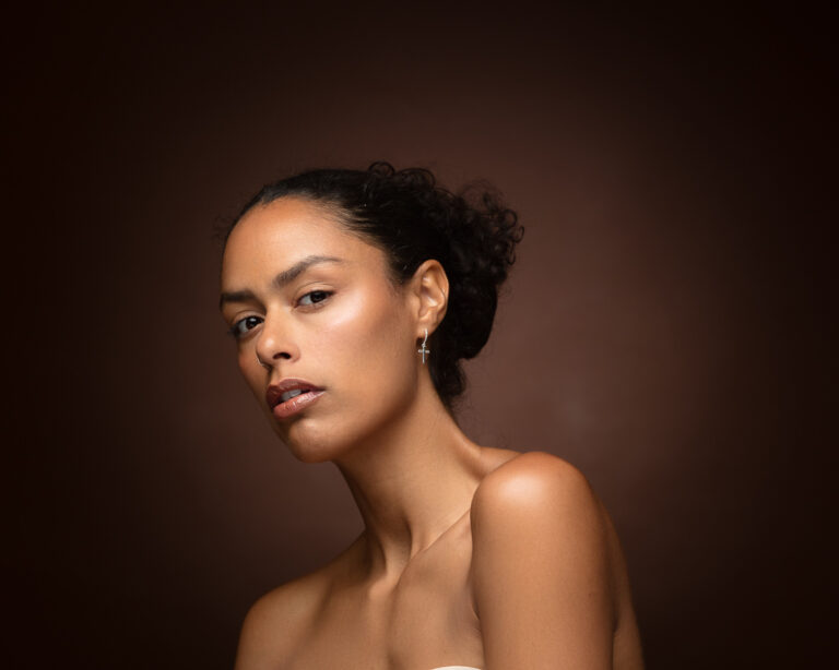 Woman with dark hair in bun wearing cross earring