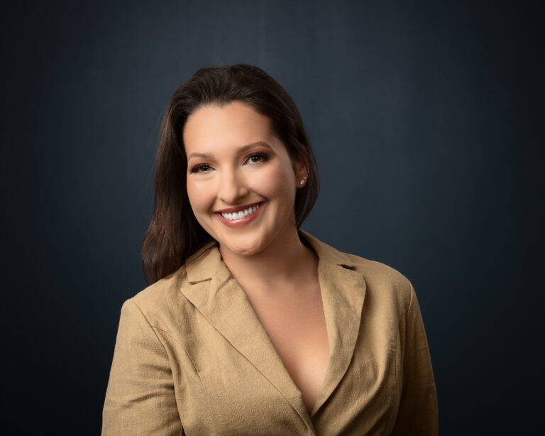 Professional headshot of smiling woman in tan blazer