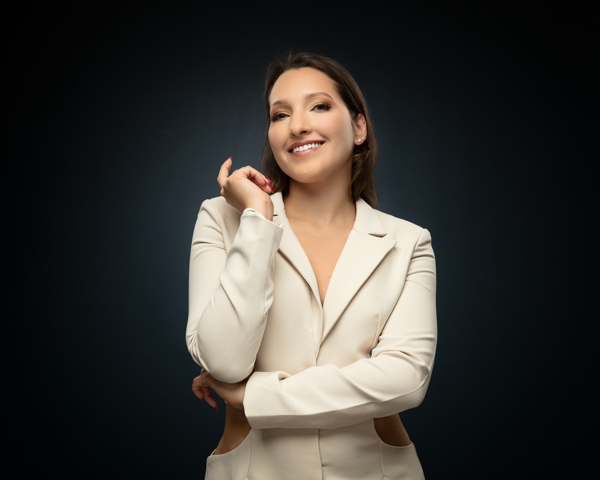 Professional woman in cream blazer smiling confidently