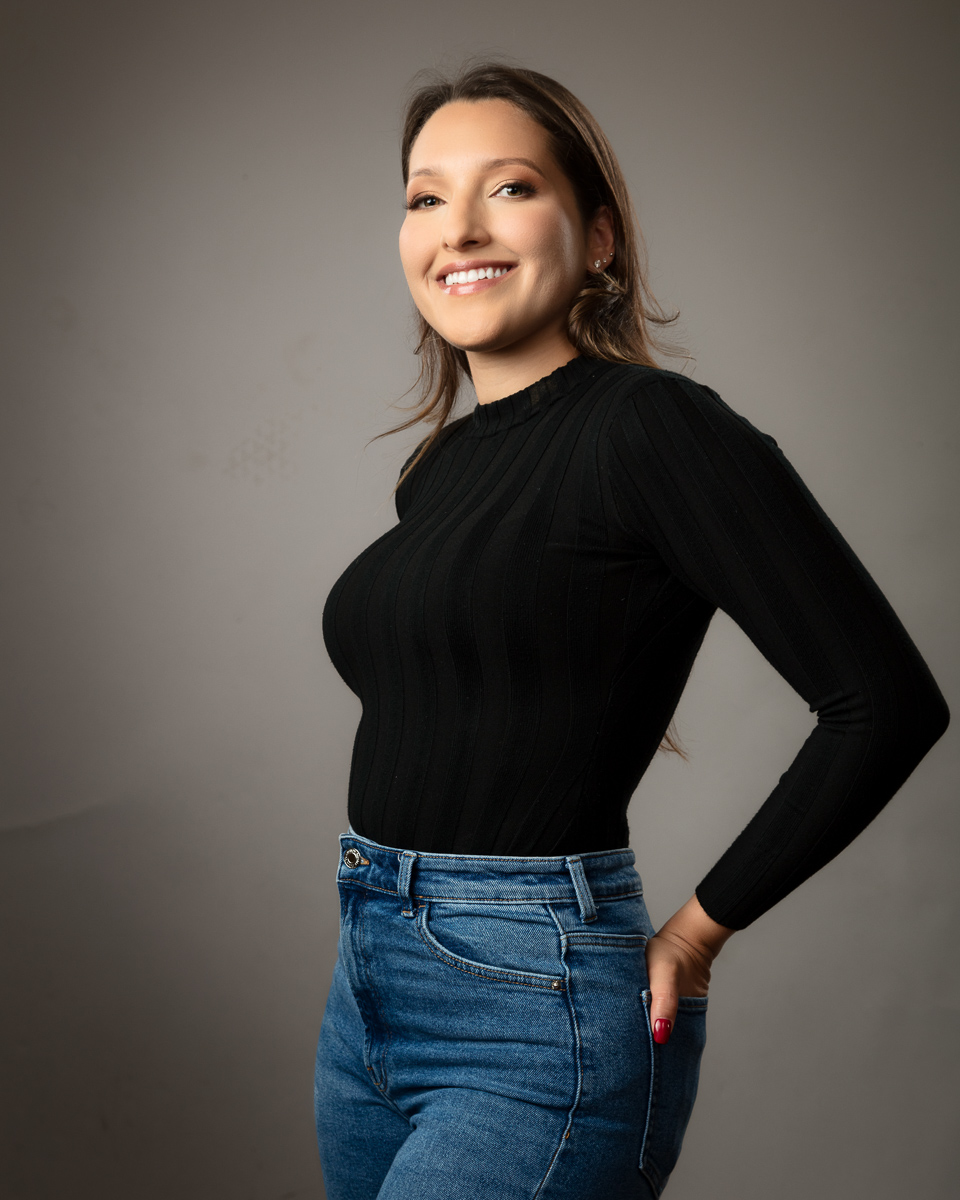Woman smiling in black jumper and blue jeans portrait