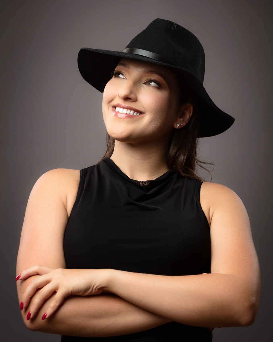 Smiling woman wearing black cowboy hat and sleeveless top