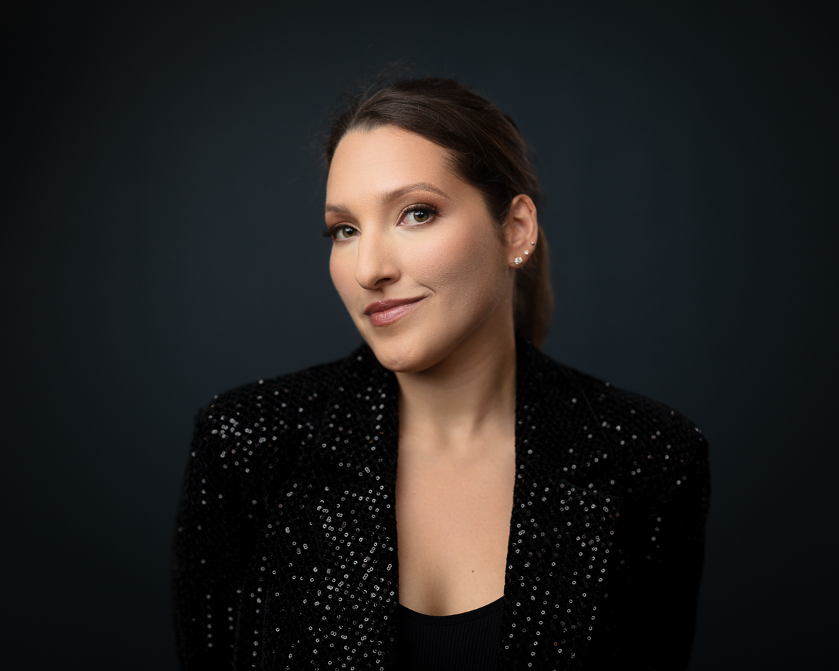 Professional headshot of woman in sequined black blazer