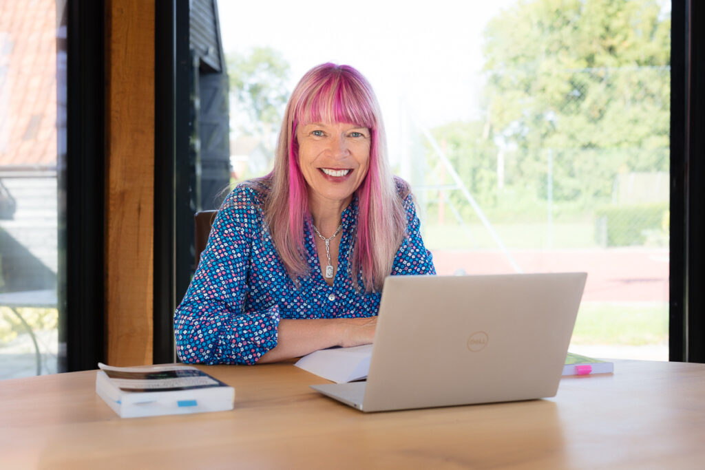 Smiling woman working on a laptop.