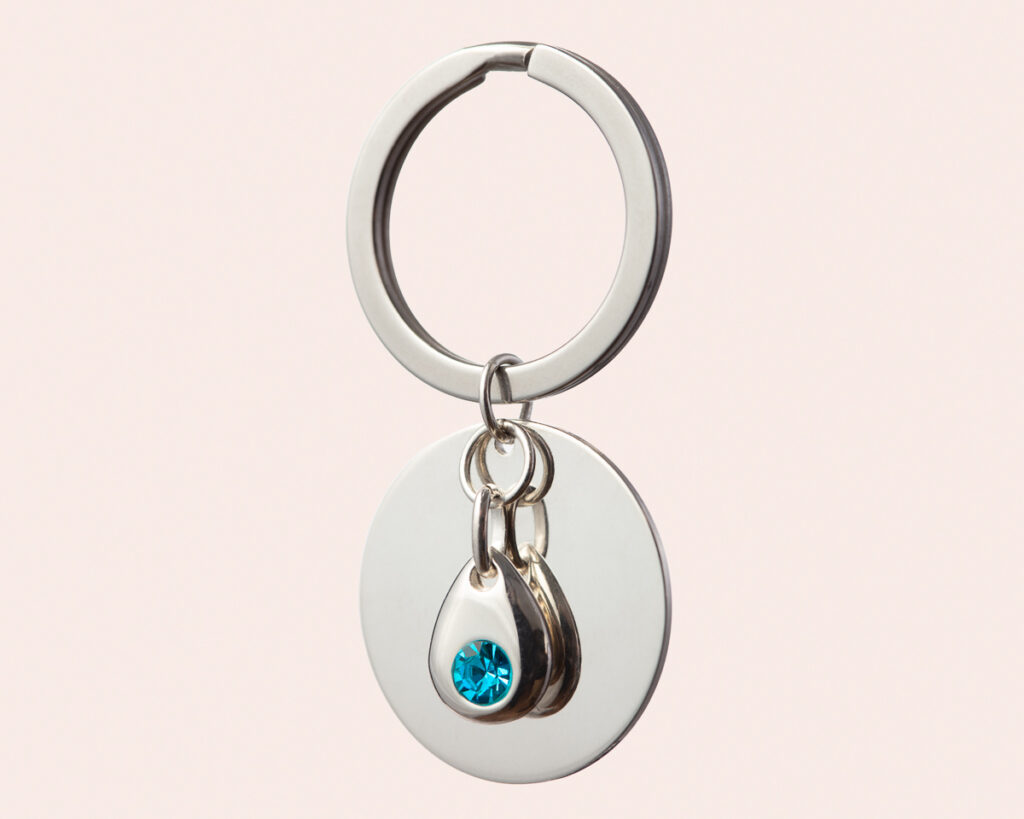 Silver keyring with blue gemstone.