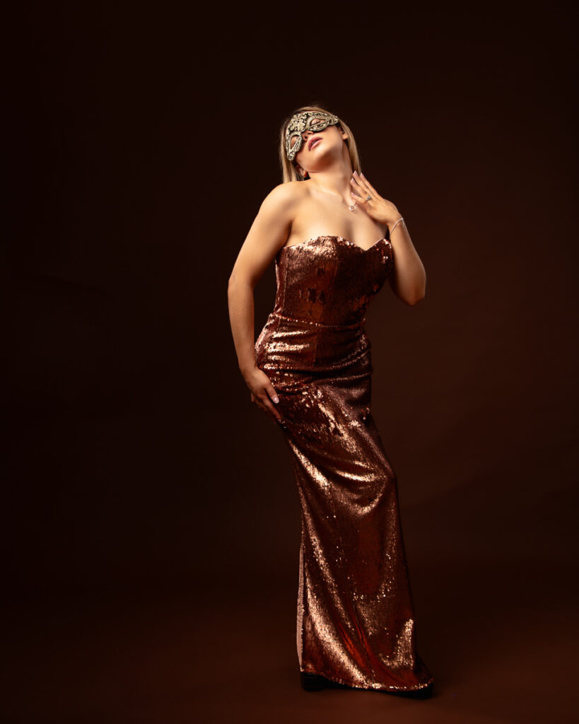 Woman in sequined dress wearing masquerade mask