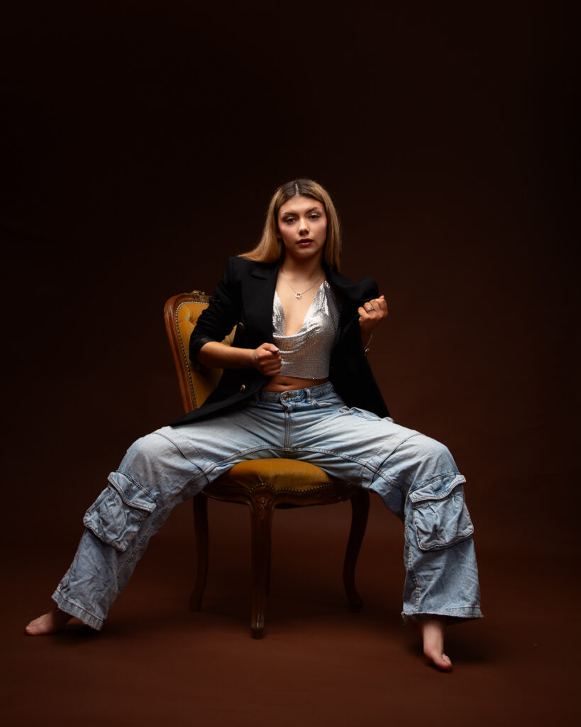 Woman posing in stylish outfit on chair