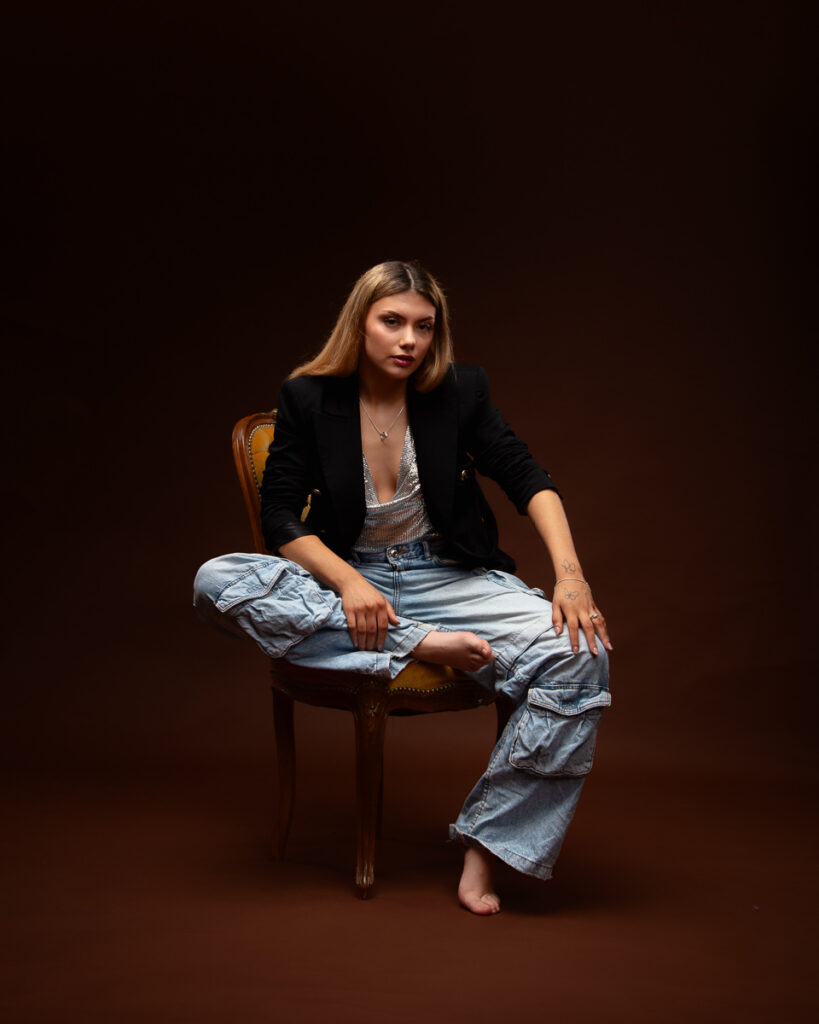 Woman seated on chair, dark background