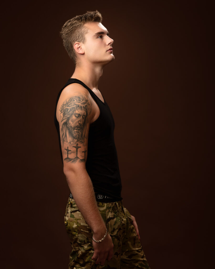 Young man with arm tattoo in a black tank top