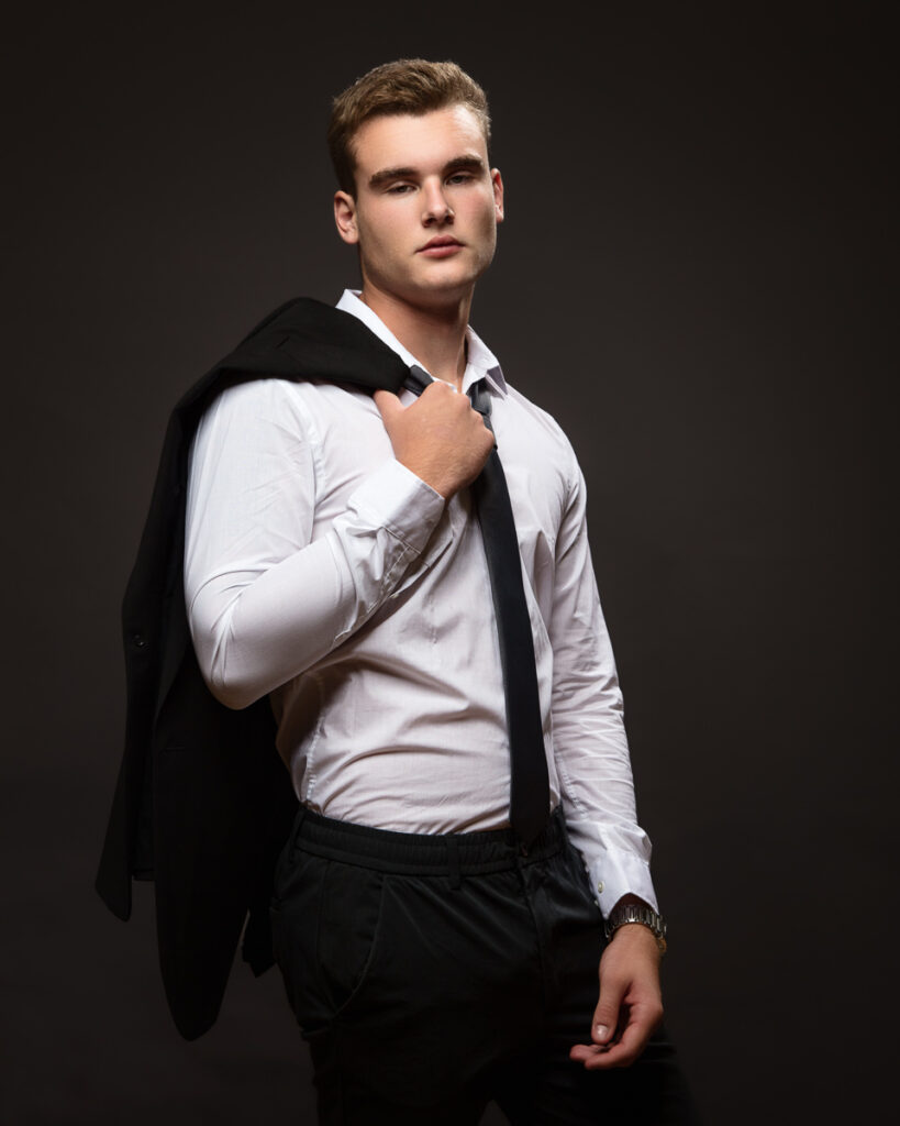 Man in white shirt, suit jacket over shoulder