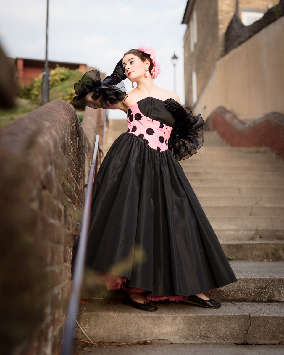 Woman in vintage dress on stairs.