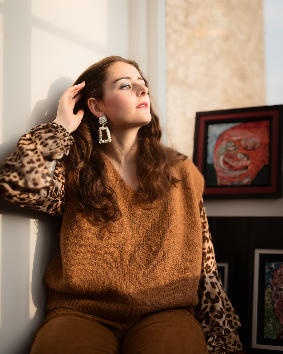 Woman with long hair by framed artwork