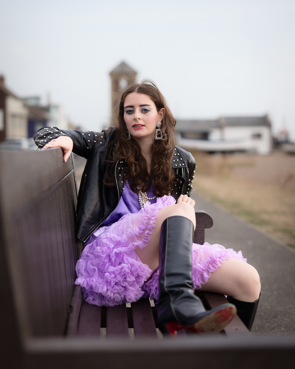 Woman in purple dress on bench.