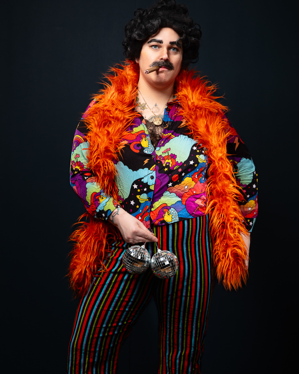 Person in colourful 70s disco attire with props.