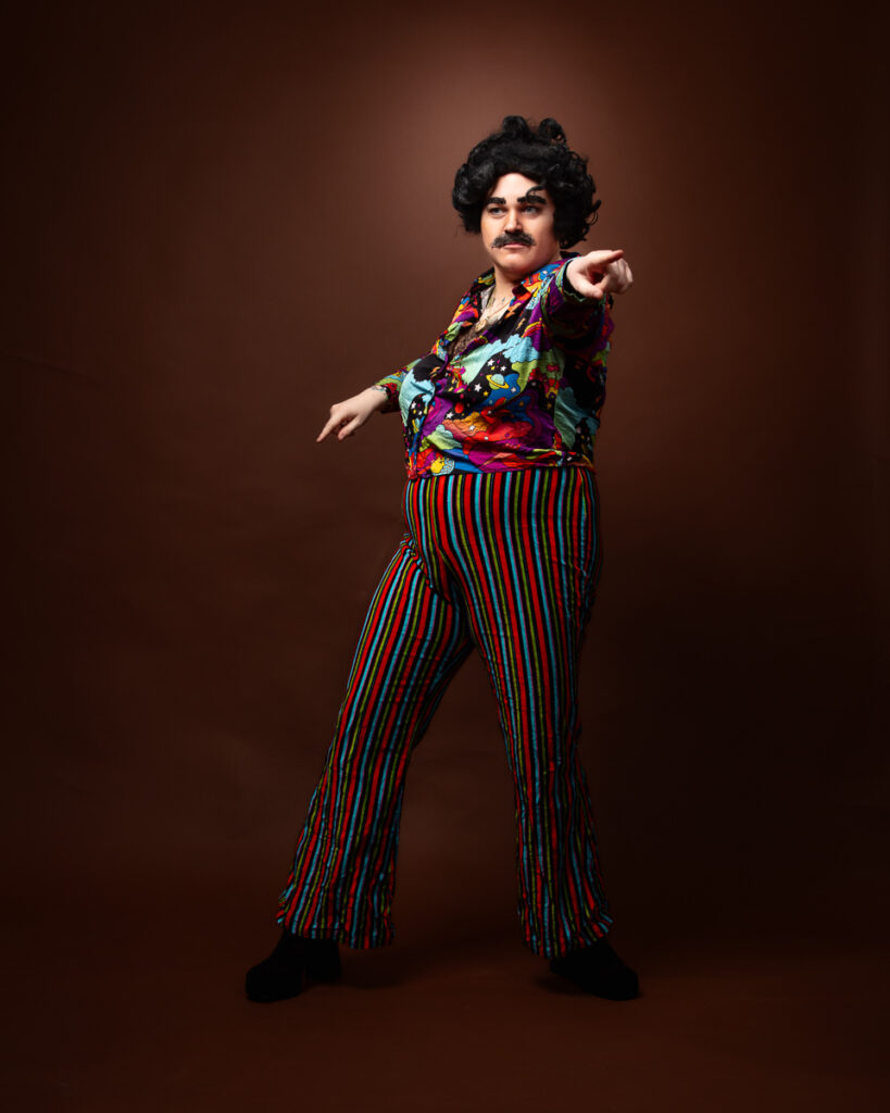 Person in colourful disco attire striking a pose