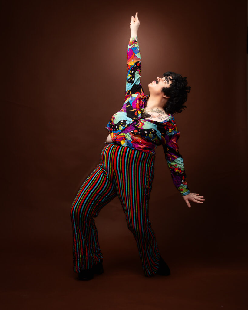 Person posing in colourful, retro outfit