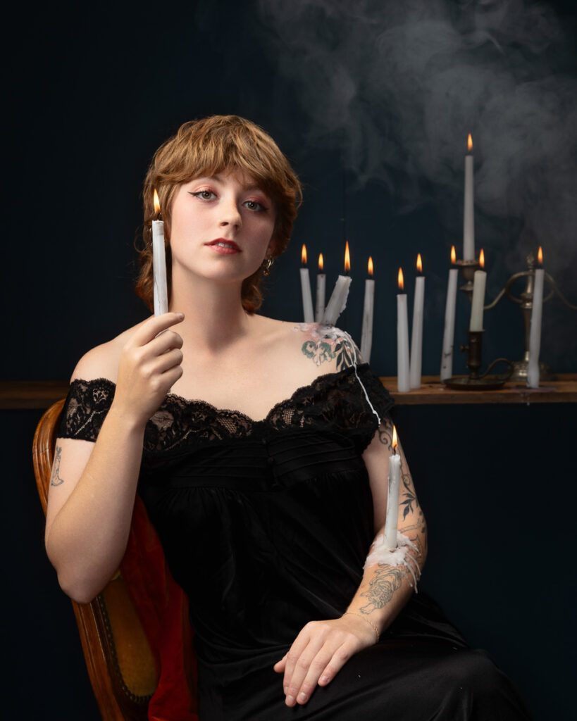 Person holding candle with smoke background.