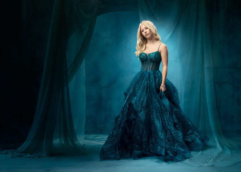Woman in elegant teal sequined gown with flowing skirt