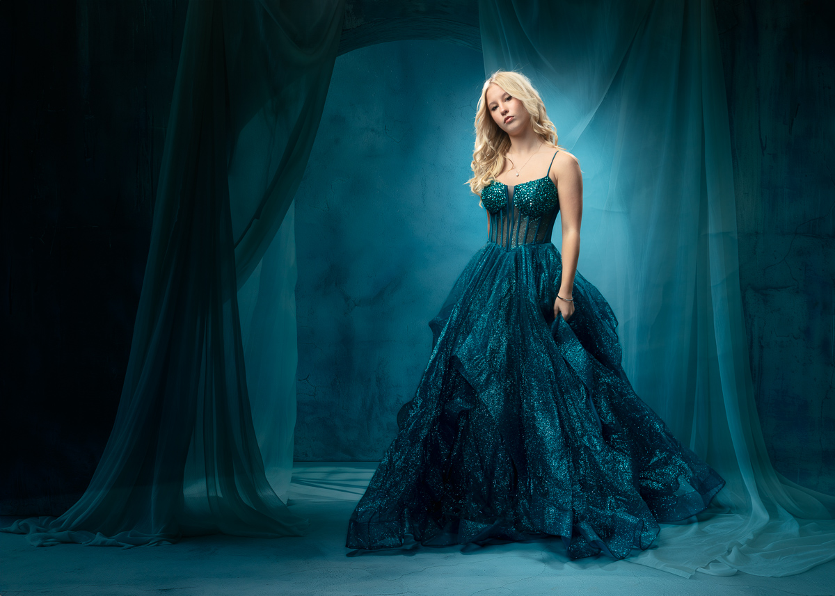 Woman in elegant teal sequined gown with flowing skirt