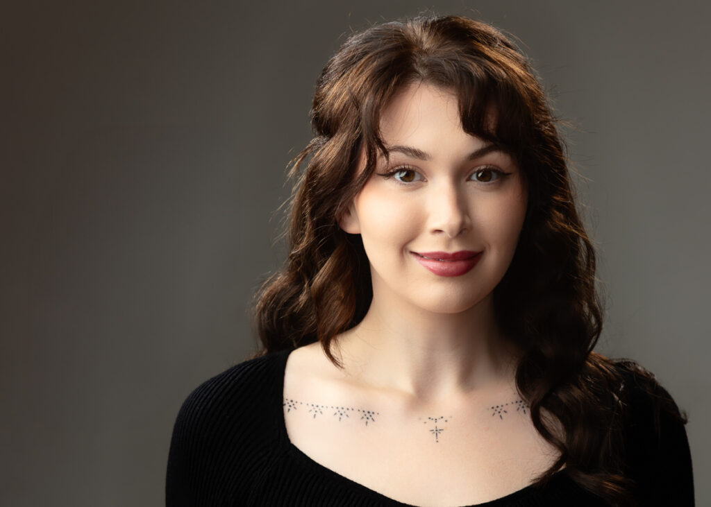 Smiling woman with dark hair and tattoos