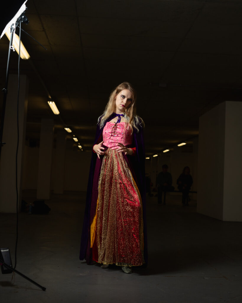 Woman in costume posing dramatically in dark room.