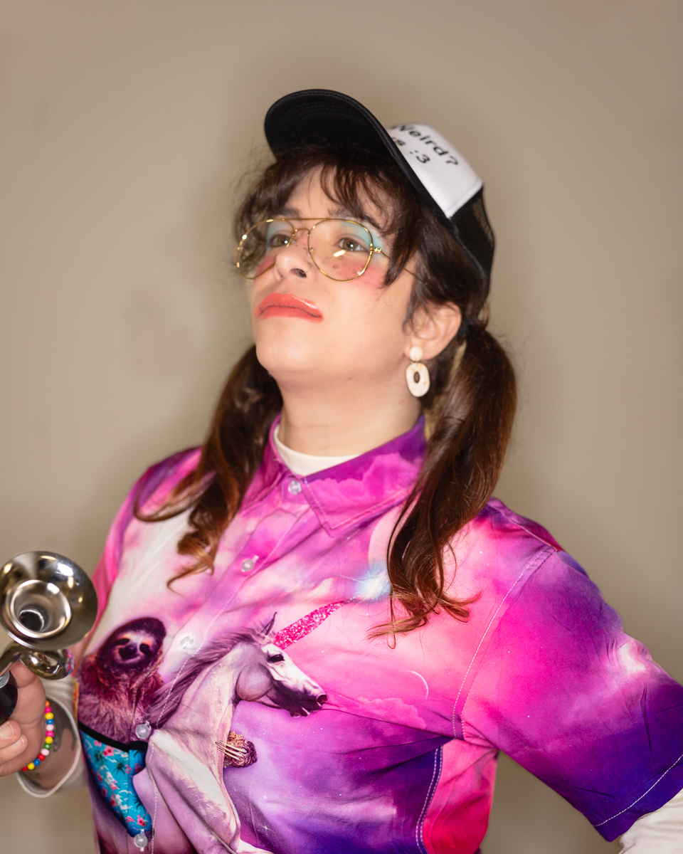 Person wearing unicorn shirt and holding a horn