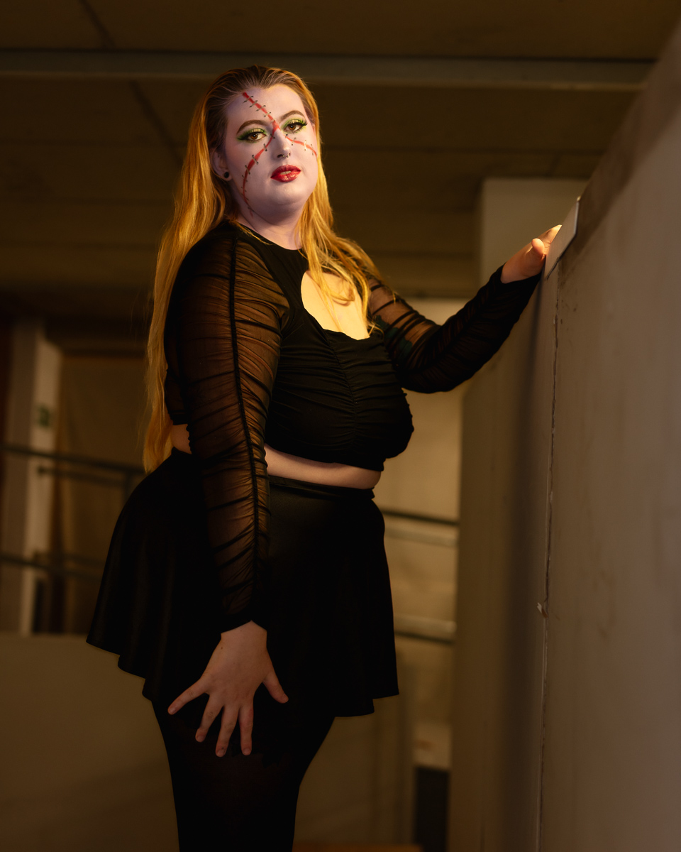 Woman with artistic face paint and long red hair indoors