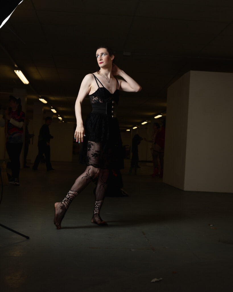 Woman in black dress posing in industrial underground space